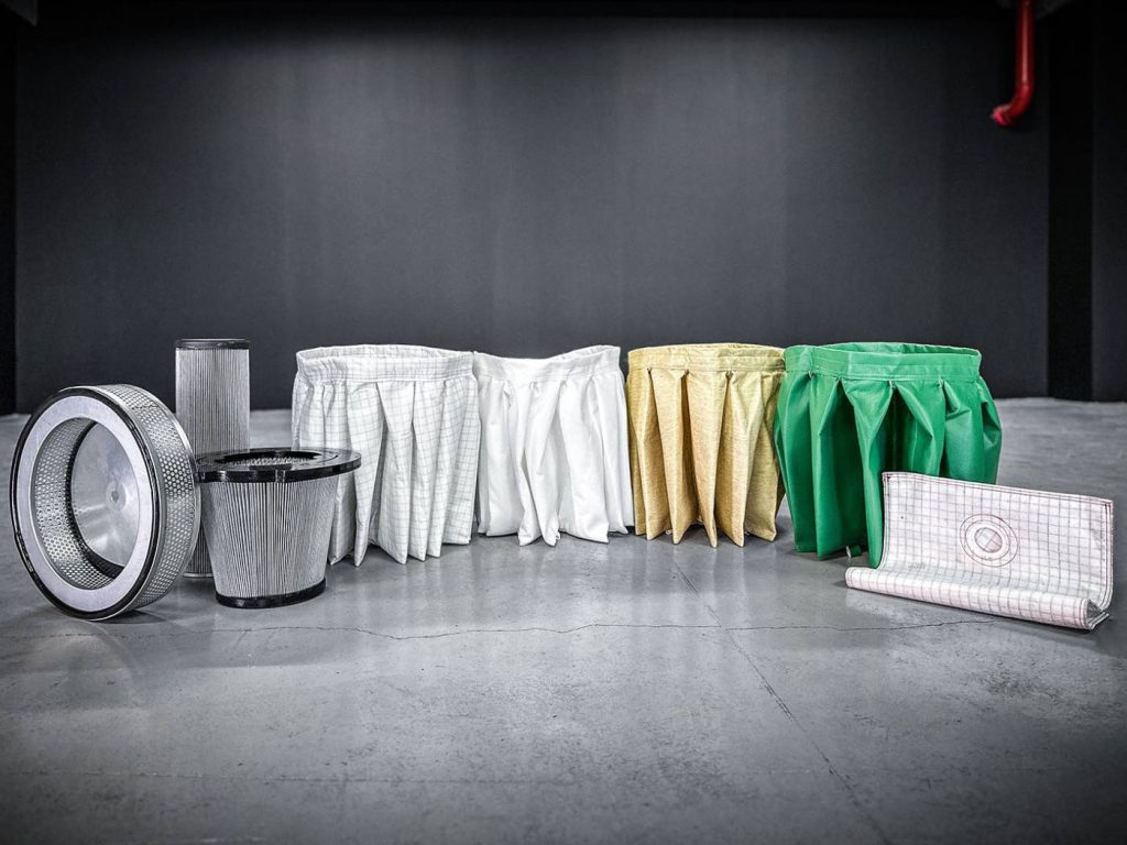 Lineup of Depureco industrial vacuum filters and accessories—cartridge, star, and bag filters arranged on a shop floor.