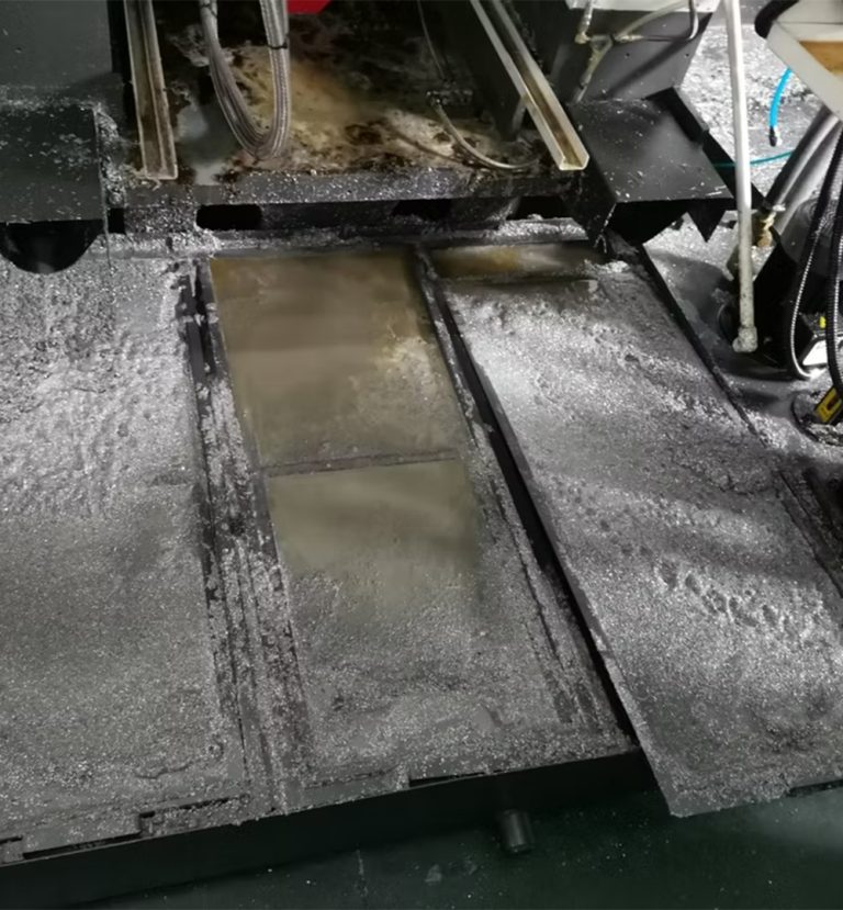 CNC sump vacuum recovering coolant, chips, and swarf from machine tank.