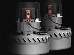 Pair of single-phase vacuum motors for wet/dry industrial vacuums with metal cooling housings, on dark backdrop.